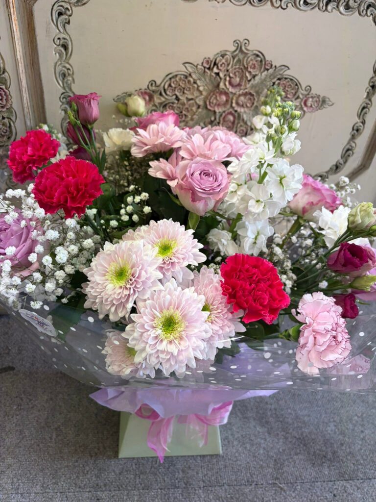 A pink and white bouquet of chrysanthemums, carnations, roses and gypsophila in a gift box, made by Bowbells Florist in Gloucester